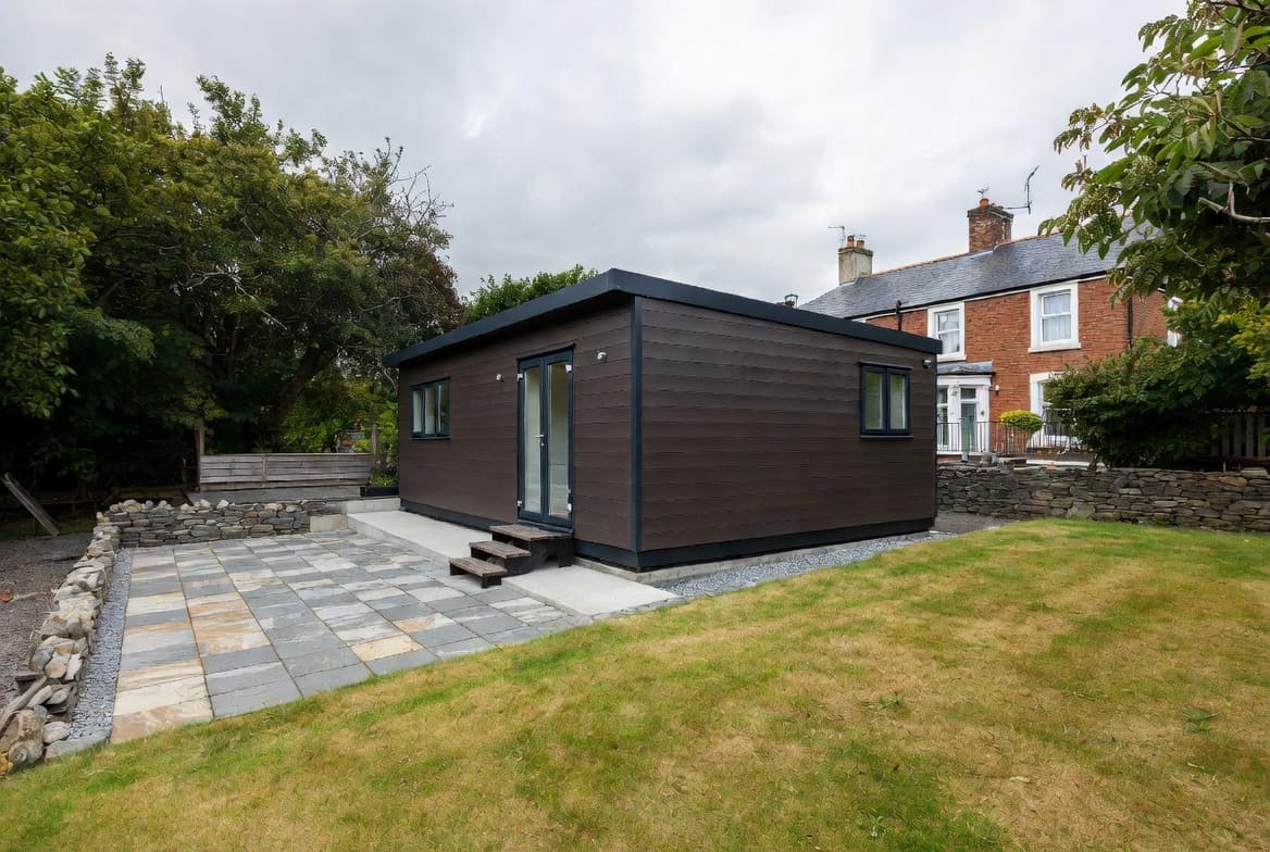 Self-contained modular unit with composite cladding and stone patio